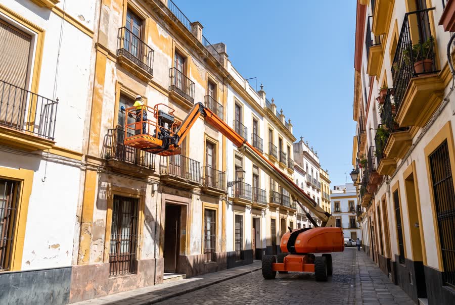 Articulated cherry picker working on the facade of a building in Spain