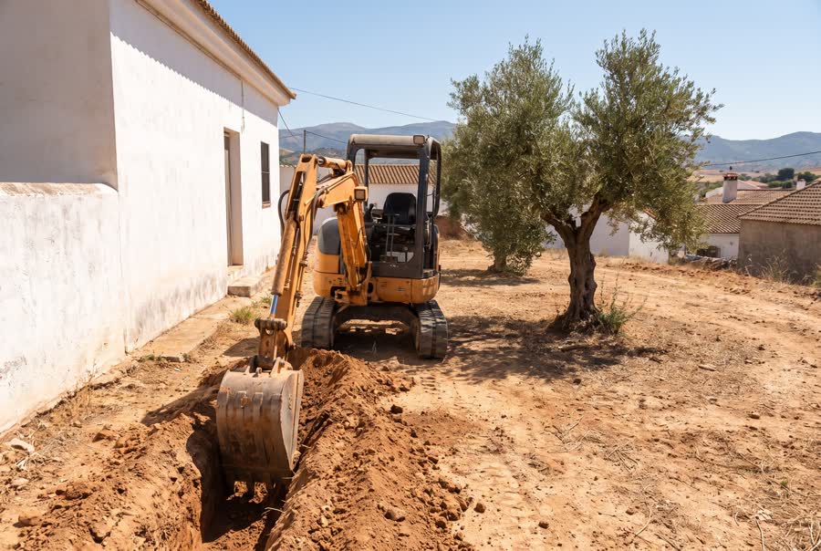 Mini digger excavating in the garden of a villa in Spain